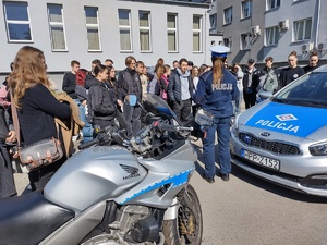 zdjęcie kolorowe zrobione na zewnątrz policjantka prezentuje motocykl